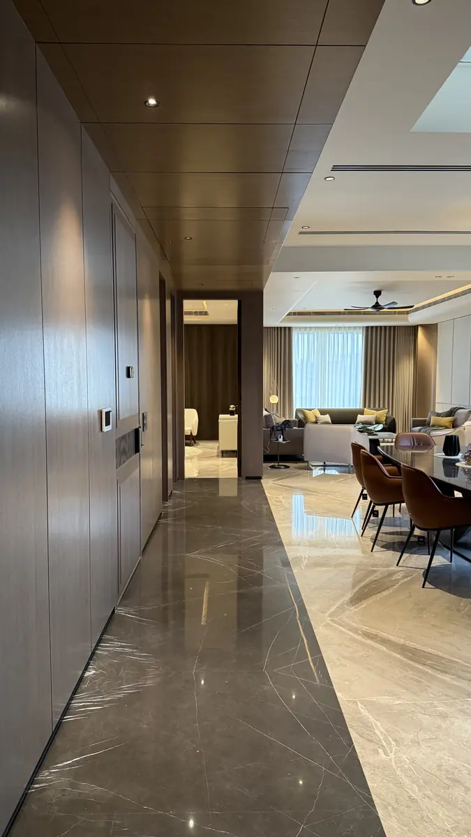 Marble passage opening into the living and dining room of a luxury builder floor in Gurgaon