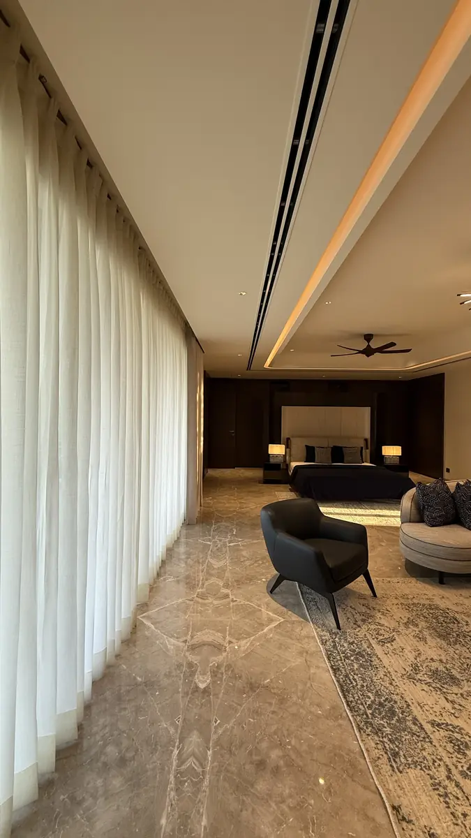 Daylight through sheer curtains reaching the back of a bedroom in a Gurgaon residence
