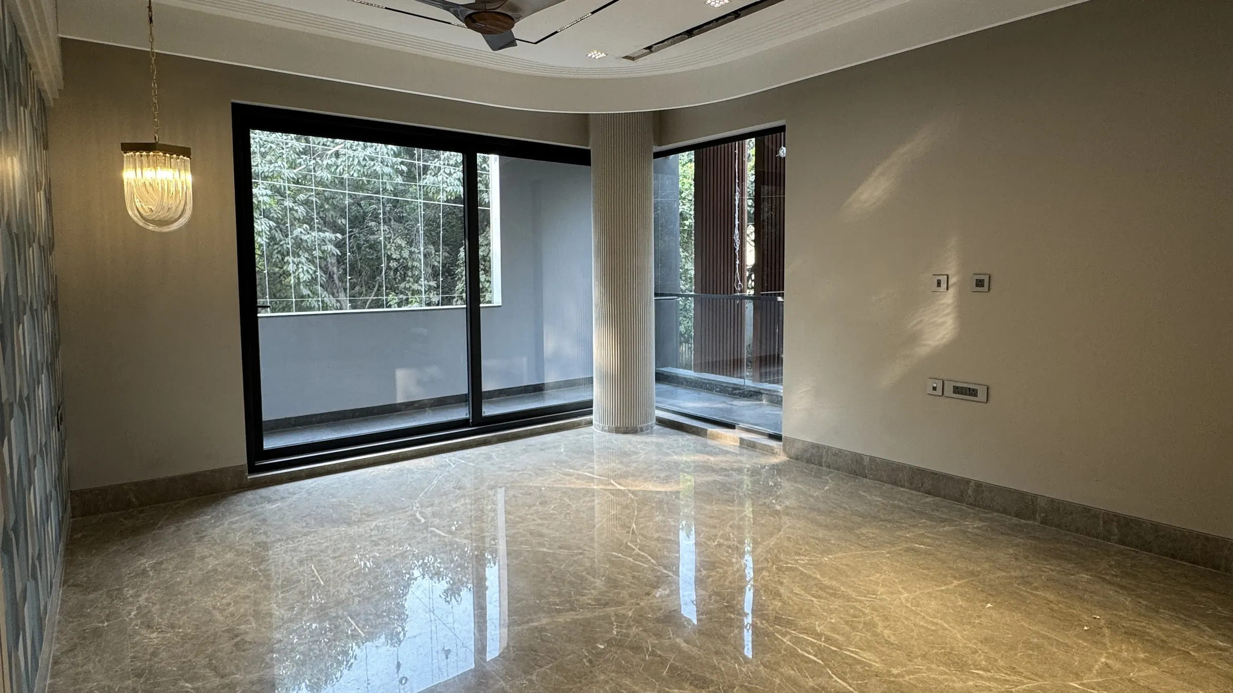 Luxury builder floor living room in Gurgaon with full-height glazing and a fluted column