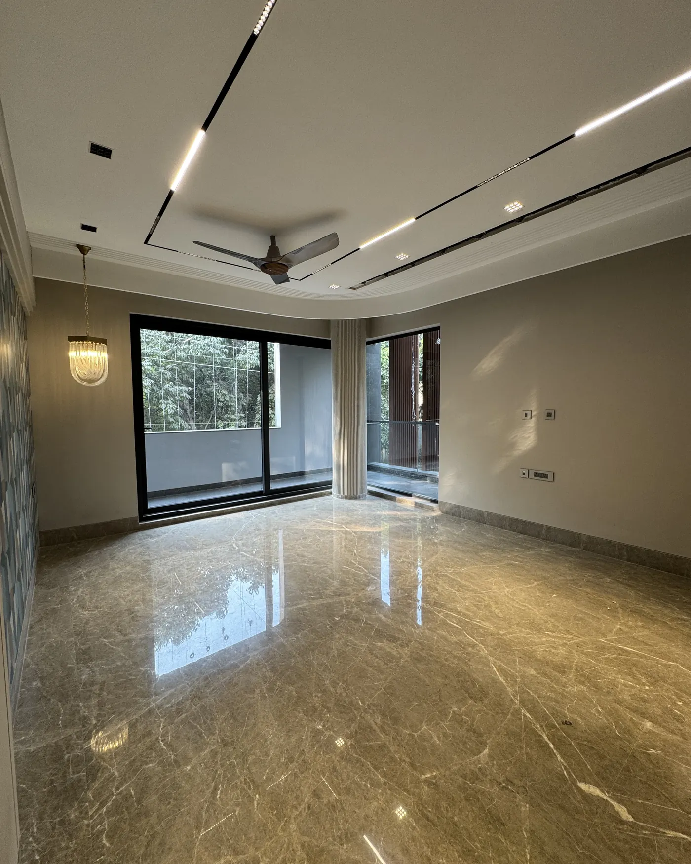Luxury builder floor living room in Gurgaon with full-height glazing and a fluted column